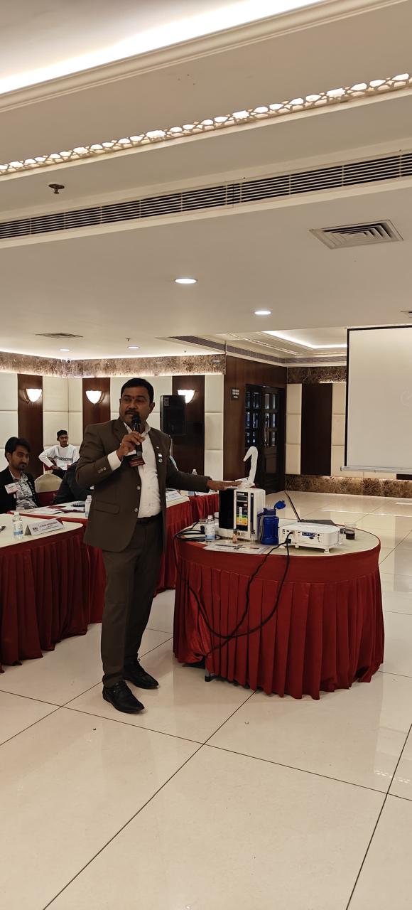 Vishnu Vardhan Reddy presenting Kangen Water on stage with a demonstration unit